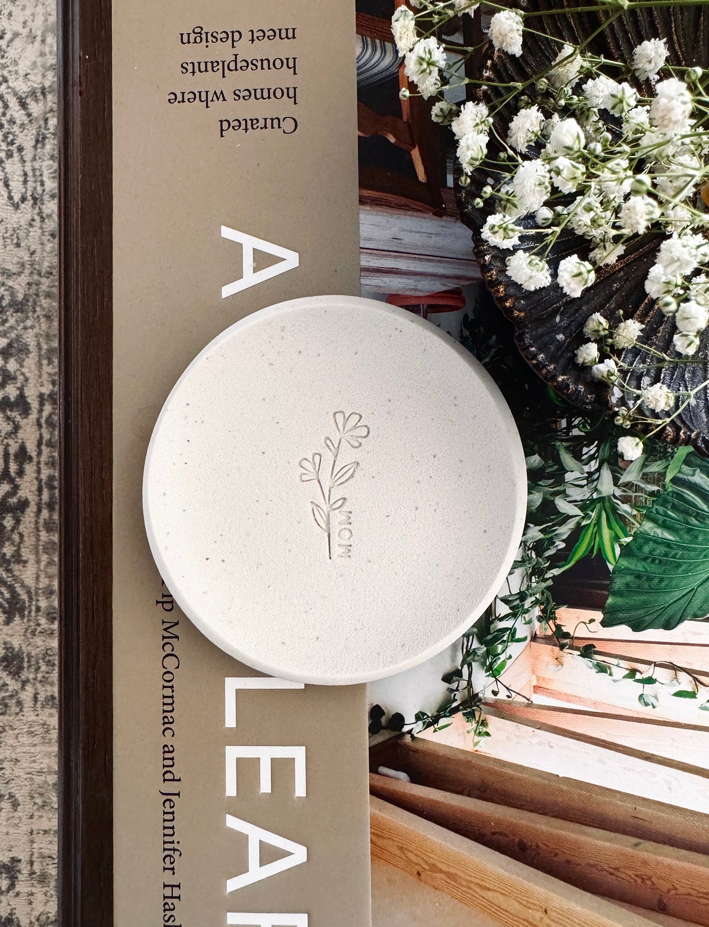 simple ring dish made of speckled white clay with floral embossed design